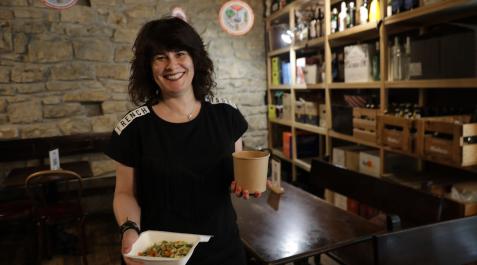 Natalia Ecay, dueña del restaurante La Antigua Farmacia, sujeta dos envases con comida para llevar Natalia Ecay, dueña del restaurante La Antigua Farmacia, sujeta dos envases con comida para llevar