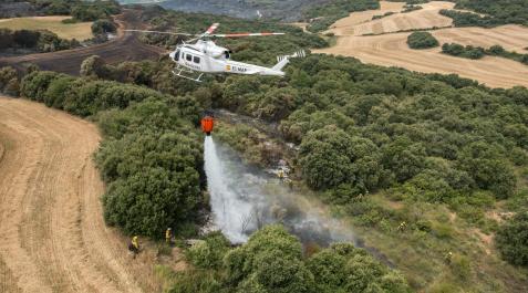 HELICOPTERO-AGUA-INCENDIO Un helicóptero vierte agua para sofocar el fuego, en un incendio anterior