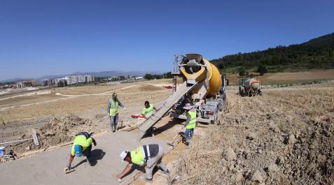 Obreros Obreros trabajan echando hormigón en Artica con 37 grados de calor