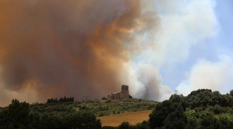 Vista de la iglesia de Sansoáin vista desde la NA-5110, en la que puede apreciarse el humo en las cercanías de esta localidad al mediodía Sansoáin
