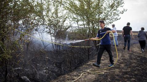 Incendios Un vecino remoja una zona junto a una vivienda