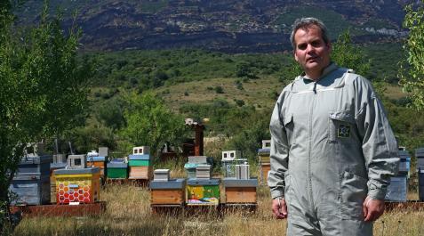 Javier del Castillo junto a sus colmenas en Yesa. Algunas, pintadas por escolares. Al fondo, la sierra de Leyre negra tras incendios. El fuego se quedó a metros Javier del Castillo junto a sus colmenas en Yesa. Algunas, pintadas por escolares. Al fondo, la sierra de Leyre negra tras incendios. El fuego se quedó a metros