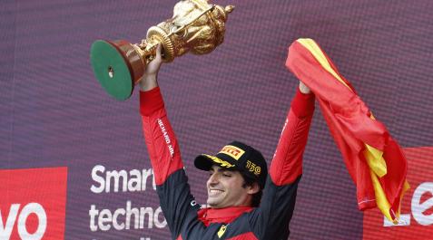 SainzGBretaña Carlso Sainz celebra su victoria en el podio del GP de Gran Bretaña con el trofeo y la bandera de España