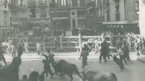 El primer encierro de 1939, un toro negro y un jabonero entran en la Plaza Consistorial atropellando a tres mozos a los que derriban El primer encierro de 1939, un toro negro y un jabonero entran en la Plaza Consistorial atropellando a tres mozos a los que derriban