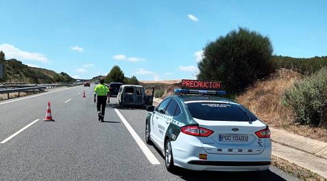 aacidentecoche Un coche patrulla de la Guardia Civil regula el tráfico detrás el vehículo que ardió en la A-12