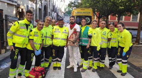 Personal de DYA de los encierros posa con la imagen de San Fermín de la hornacina Personal de DYA