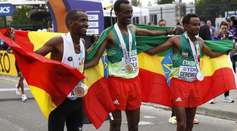 Los etíopes Tamarit Tola (centro - oro), y Mosinet Geremew (dcha. - plata), con el belga Bashir Abdi (izda - bronce) al terminar la maratón enel Mundial de Eugene