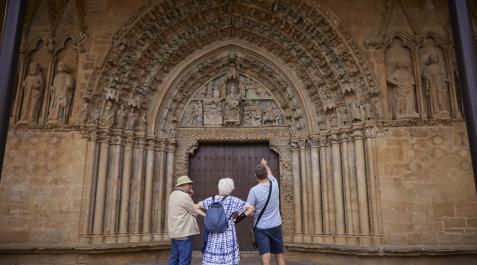 Un grupo de turistas observa detalladamente el imponente pórtico de la iglesia de Santa María la Real, en Olite Olite