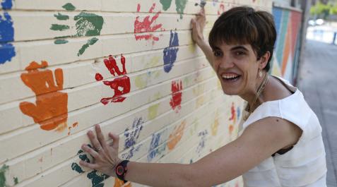 La pamplonesa Idoia Jorajuría Galetx, de 35 años, delante del mural de manos de colores del centro de educación especial Andrés Muñoz Garde, en Iturrama, donde imparte clase Idoia Jorajuría