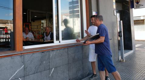 Ribaforada Félix Ansó, dueño del bar, junto a su hijo Jorge, charlan ayer con unos clientes que están justo en la mesa donde se encontraban Ángel Zardoya, Teresa Sánchez y su hija Maite