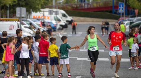 Carrera Popular Artica Jóvenes aficionados animan en la recta final a dos de los participantes de la prueba