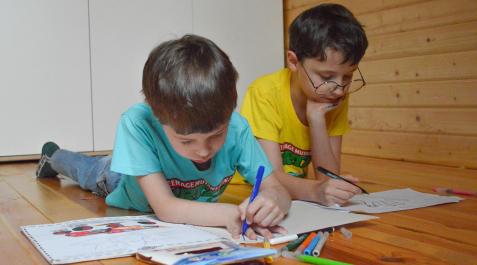 gafas-nino Dos niños, uno de ellos con gafa, dibujan en el suelo