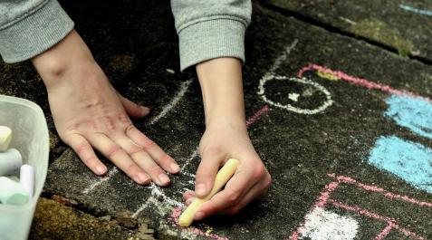 tizas-dedos Un niño pintando en el suelo con unas tizas