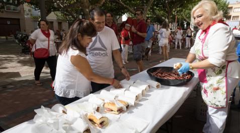 Dos personas recogen bocadillos de salchichas en uno de los almuerzos Dos personas recogen bocadillos de salchichas en uno de los almuerzos