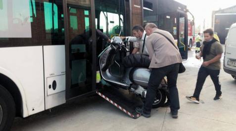 20654243 Dos empleados del transporte suben una moto de un compañero a una villavesa