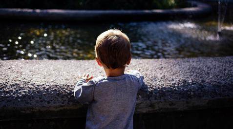 niño Un niño, frente a una fuente