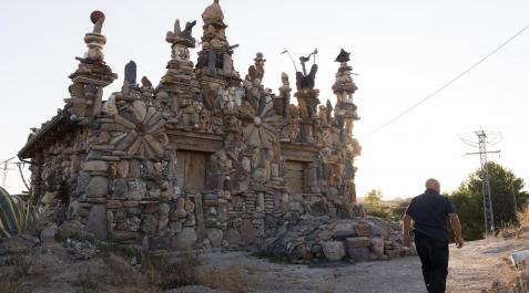 2021-1590433 Armando Baigorri, de espaldas, junto a la casa que ha ido recubriendo con más de un millón de piedras en Monteagudo.