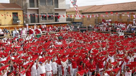 CORTES Los asistentes al lanzamiento del cohete de las fiestas de San Miguel de Cortes alzan sus pañuelos tiñendo de rojo la plaza del Ayuntamiento.