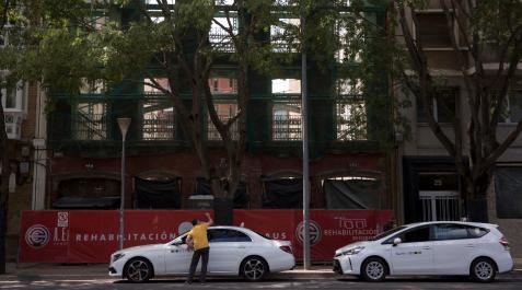 Dos taxis junto a un edificio en rehabilitación, metáfora de la situación que vive este servicio público Dos taxis junto a un edificio en rehabilitación, metáfora de la situación que vive este servicio público