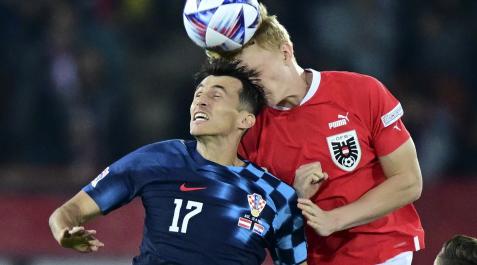 Budi Budimir intenta ganar el duelo por alto en el partido contra Austria