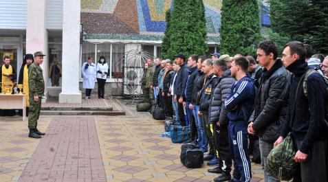 reclutamiento-rusia Hombres reclutados rusos asisten a una ceremonia de despedida frente a una oficina de reclutamiento en Bataysk