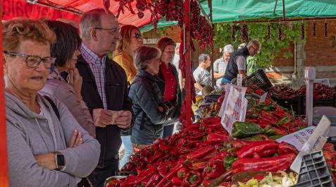 Varias personas esperan en un puesto de pimientos de Puente la Reina a ser atendidas mientras observan y eligen el tipo de pimiento que van a adquirir Varias personas esperan en un puesto de pimientos de Puente la Reina a ser atendidas mientras observan y eligen el tipo de pimiento que van a adquirir