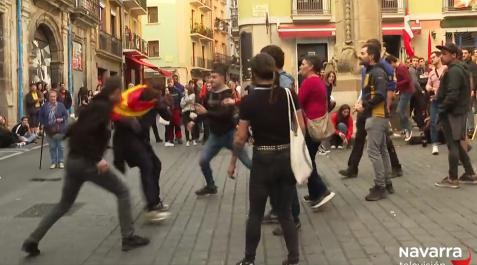 Momento en el que varias personas intentan arrebatar la bandera de España a otra durante los incidentes