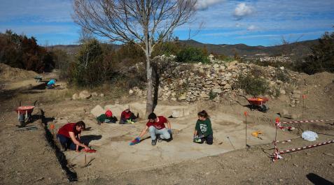 Paloma Lorente (izq.), directora técnica de la excavación, trabajando el pasado lunes en la plaza del Foro de Santa Criz junto a varios alumnos del Diploma de Arqueología de la Universidad de Navarra. Al fondo, el nuevo sondeo que se ha abierto en esta campaña.