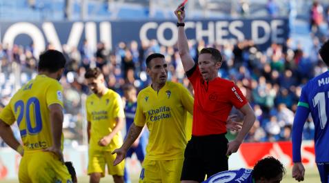 El árbitro Hernández Hernández (3-d) muestra la tarjeta roja al defensa del Cádiz Luis Hernández