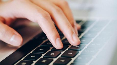 Una mujer escribiendo en un ordenador Una mujer escribiendo en un ordenador