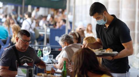 CAMARERO Un camarero atiende a unos clientes en una terraza