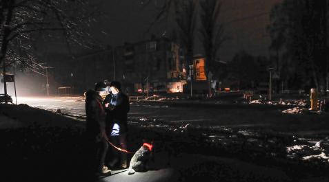 ucrania Dos personas se alumbran con un teléfono móvil en una calle oscura de Kiev, donde la mitad de la ciudad sigue sin electricidad y dos tercios de los hogares no tienen calefacción