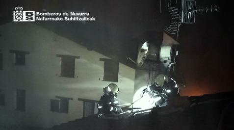 Bomberos, trabajando en el tejado de la vivienda incendiada Bomberos, trabajando en el tejado de la vivienda incendiada