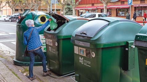 CONTENEDORES Una persona introduce una bolsa en un contenedor no adaptado abierto con tarjeta