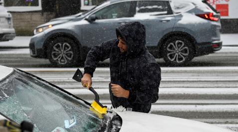 Un hombre rasca el hielo de su coche en Chicago Un hombre rasca el hielo de su coche en Chicago