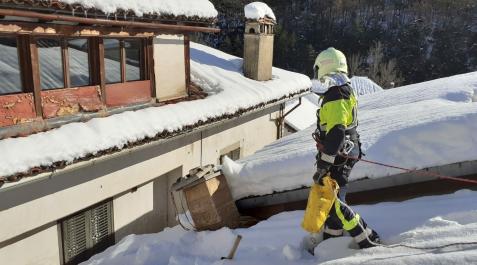 bomberos-nieve Un bombero sobre el tejado comprobando el estado de la nieve y el riesgo de caída
