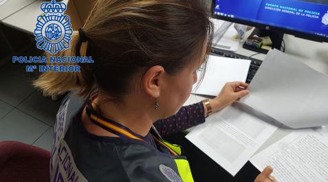 POLICIA NACIONAL DOCUMENTACION Una agente de la Policía Nacional analiza la documentación presentada sobre el timo del buen samaritano