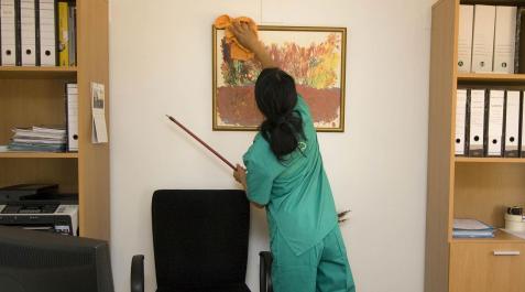 trabajadora-limpieza Una empleada del hogar limpiando un despacho