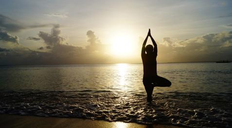 Una persona hace yoga en la plaza al amanecer.