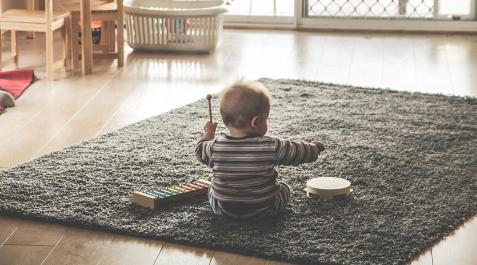 Niño jugando sobre una alfombra Niño jugando sobre una alfombra