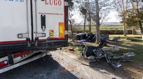 Accidente en Ribaforada El coche, un Audi A7, al fondo de la imagen, impactó primero contra un árbol, luego contra la parte trasera de este camión estacionado y finalmente contra otro árbol.