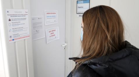 Una paciente lee los carteles indicativos de la huelga en el centro de consultas Príncipe de Viana.