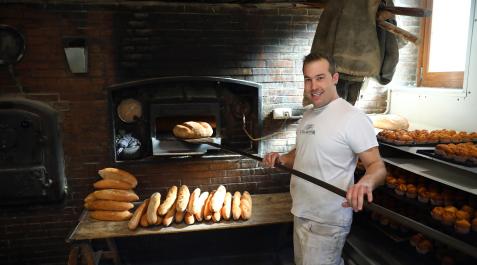 Burgui Rubén Ezker Sanz saca una hogaza del horno en la panadería de Burgui.