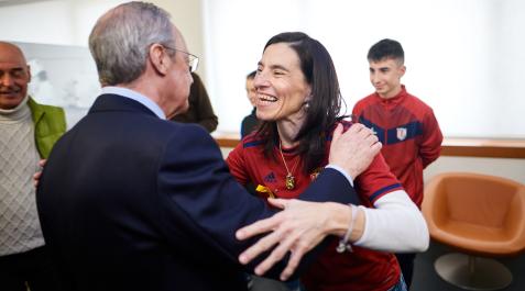 CUN SAludo entre Florentino Pérez, presidente del Real Madrid, y Marta Alonso, investigadora navarra. Detrás, el hijo de ésta con el chandal del Rotxapea