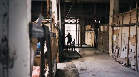 Edificio en CubaCalle Un joven cubano y un niño juegan en el pasillo de un edificio abandonado - La Habana, Cuba, diciembre de 2022.