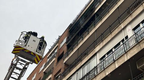 Bomberos frente a la fachada incendiada Bomberos frente a la fachada incendiada
