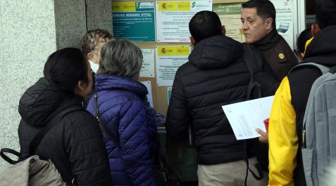 Un empleado de seguridad da instrucciones a un grupo de ciudadanos que no ha cita previa en Pamplona