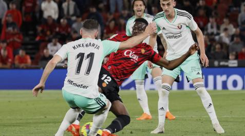 Kike Barja trata de impedir que Baba se lleve el balón ante la mirada de Aimar Oroz Kike Barja