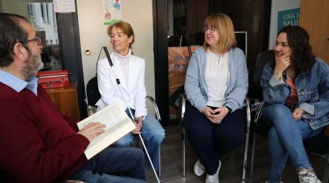 Retina Juan Manuel Martín Domínguez lee un libro a Mari José Casado Aguilera, Esperanza Zarzuelo Núñez y Ana Idoia Albéniz Merino, de la Asociación Retina Navarra.