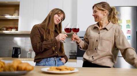 vino dia madre Madre e hija brindan con sendas copas de vino para celebrar el Día de la Madre.